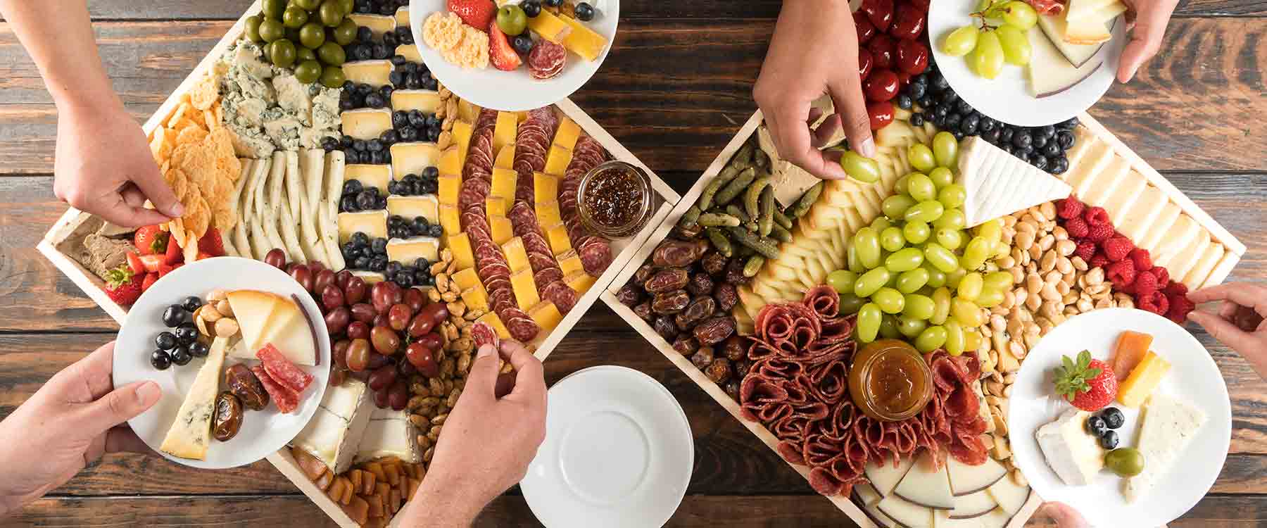 Hands filling plates from party platers