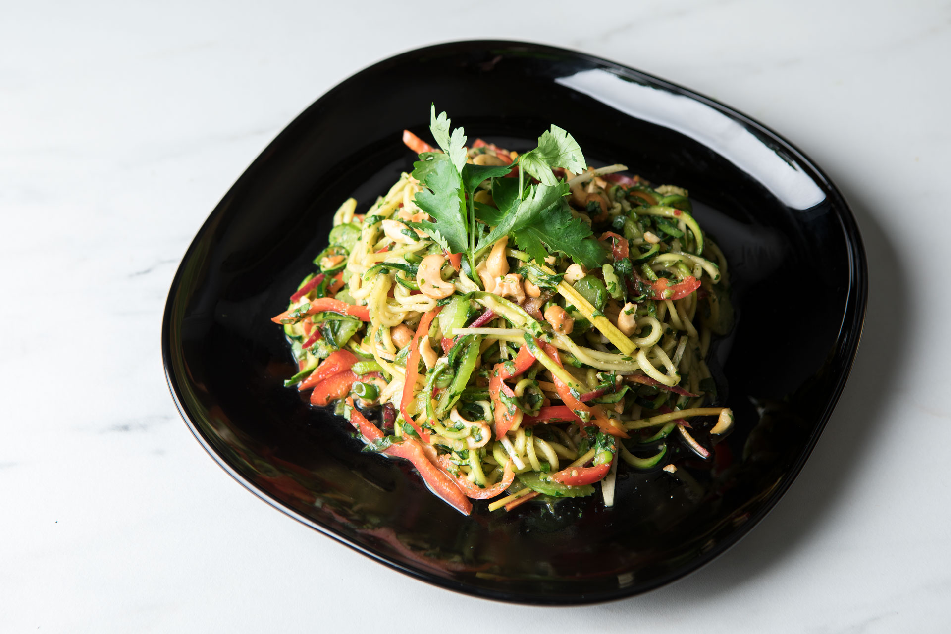 thai zoodle salad on a black plate
